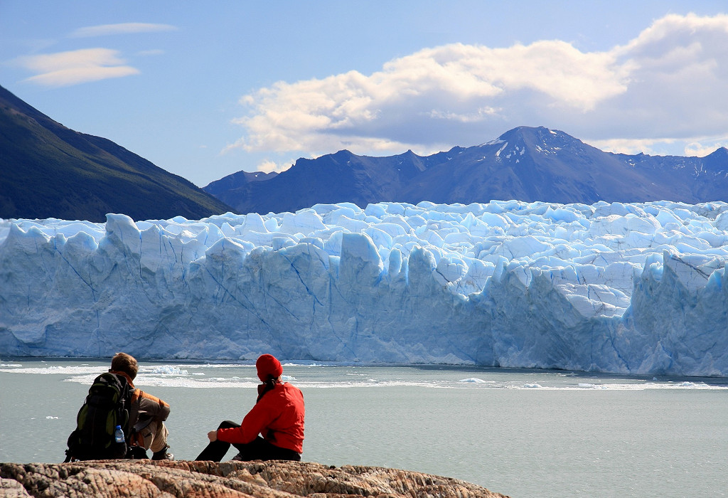 People sat near a glacier in Argentina