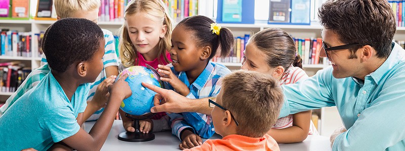 School children looking at a globe